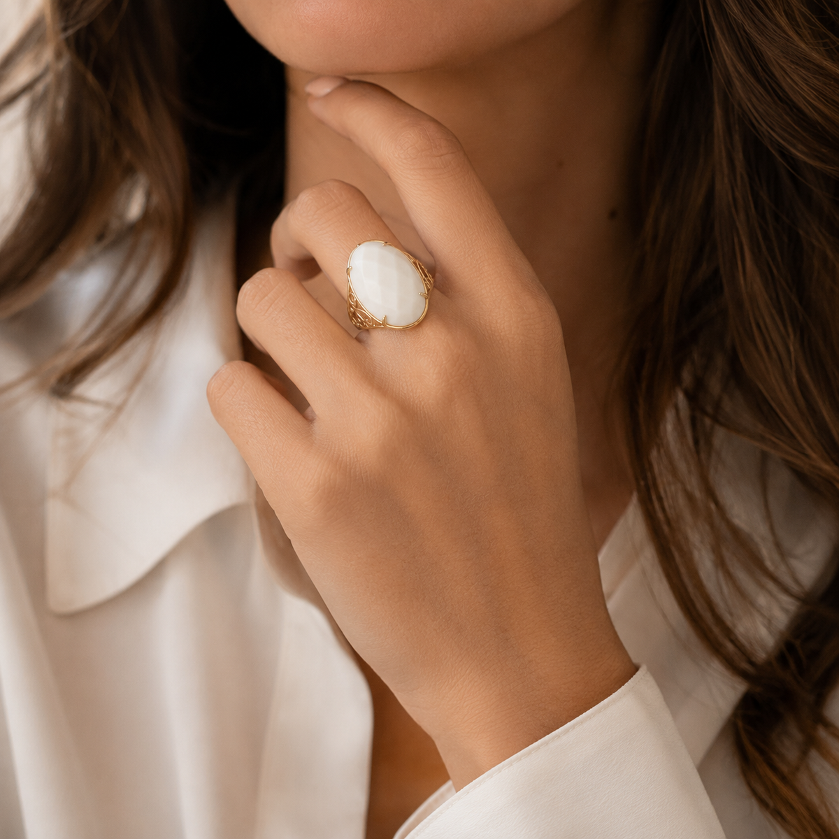 Anillo White dorado con piedra blanca efecto nacarado puesto en modelo