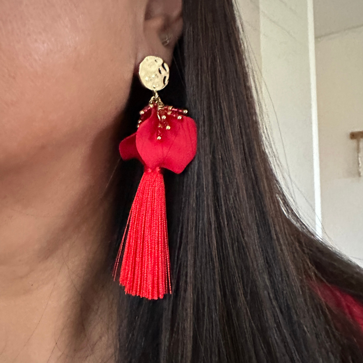 Aro base dorada palitos de mostacillas petalos penacho de hilo rojo puestos