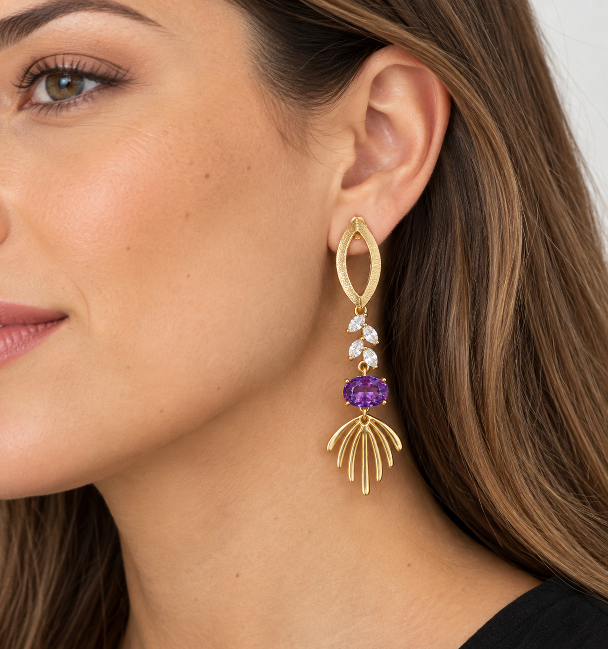 Aro largo dorado con cristal violeta y cristales transparentes puesto en oreja de modelo MCJoyas.