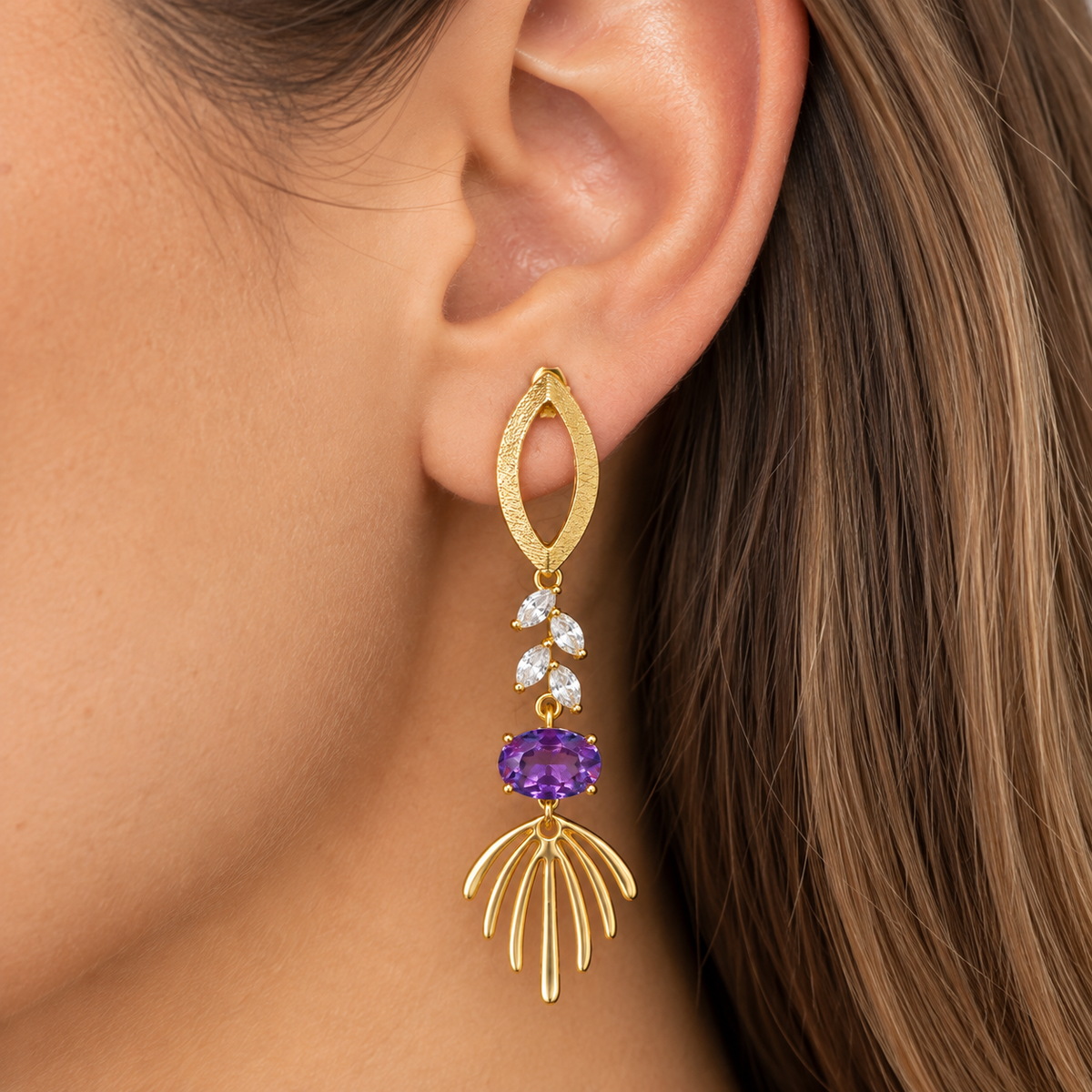 Aro largo dorado con cristal violeta y cristales transparentes puesto en oreja de modelo MCJoyas