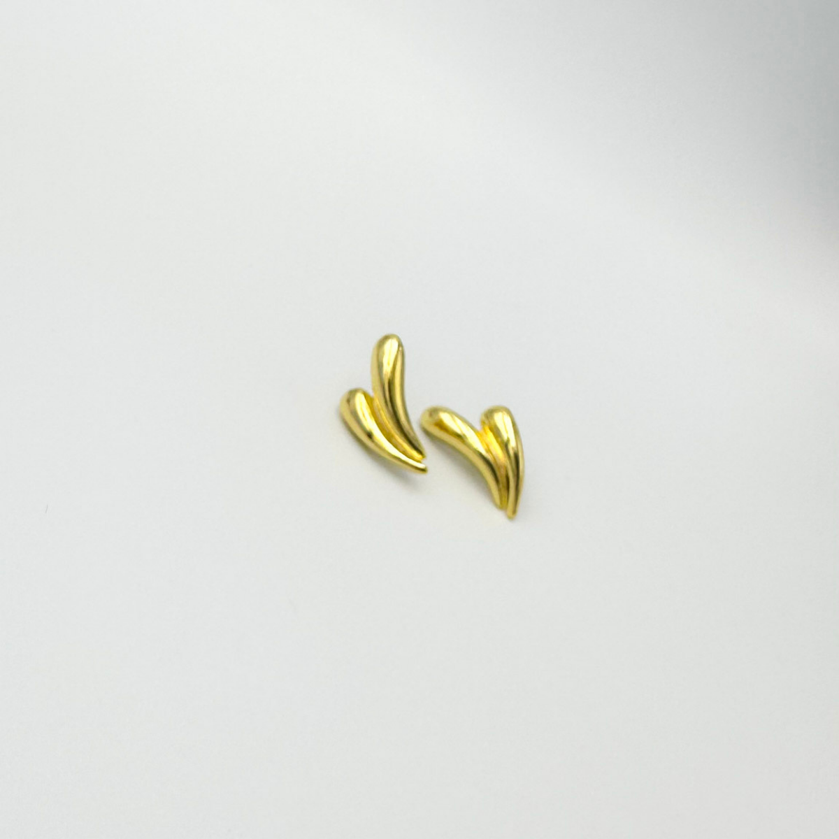 Aros Aura Dorada de diseño curvo y acabado dorado brillante sobre fondo claro.1