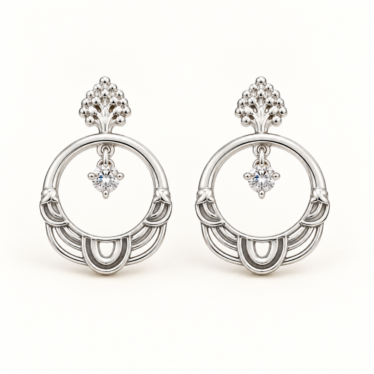 Aros Karla Plata de diseño circular con cristal brillante y detalles ornamentales en acabado plateado.