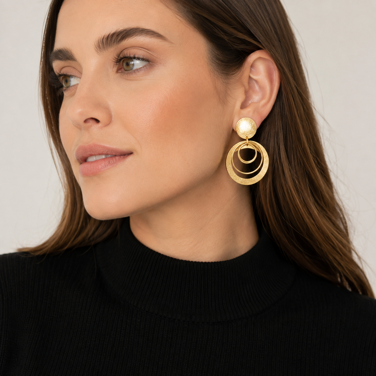 Aros Sabine Gold dorados con círculos calados y textura artesanal puestos en modelo MCJoyas