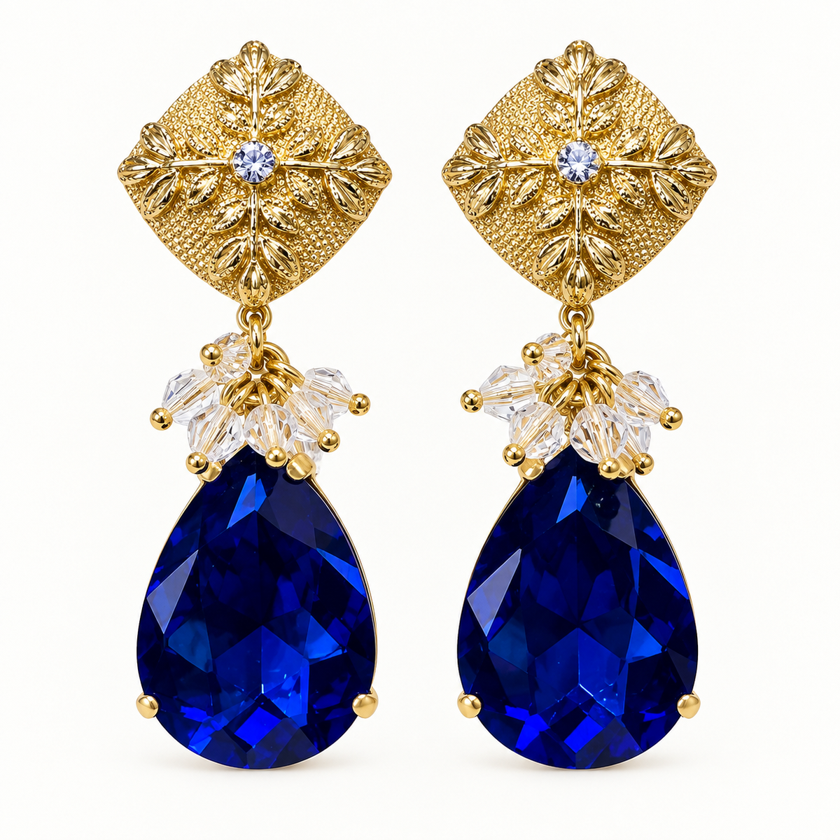 Aros dorados de fiesta con base floral, cristales transparentes y gota de cristal azul facetado MCJoyas