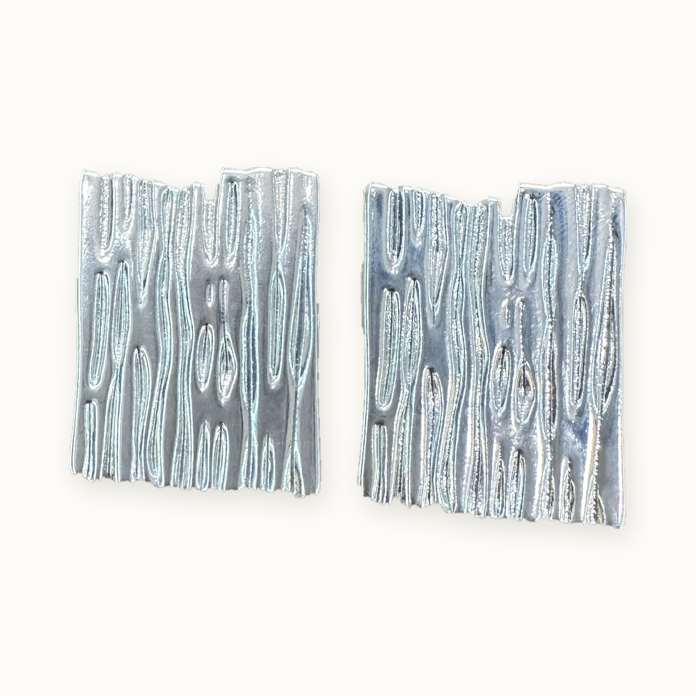 Aros plateados rectangulares con textura orgánica en relieve y acabado brillante MCJoyas.