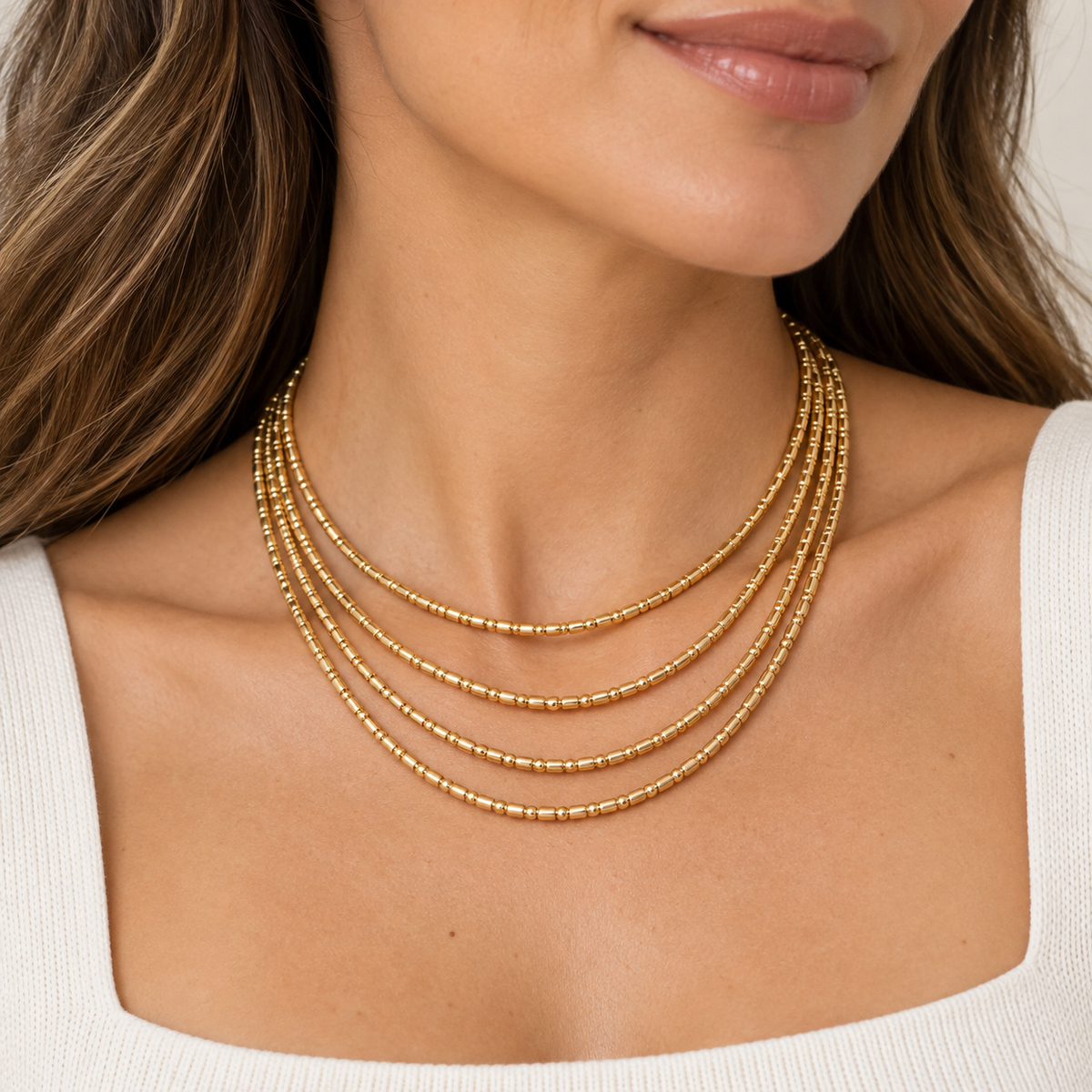 Collar dorado multivuelta de mostacillas en modelo, joya versátil que también se usa como pulsera”