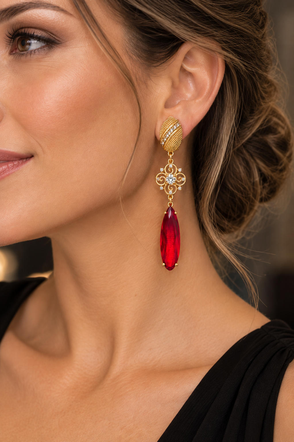 Modelo con vestido negro usando aros largos dorados con cristal rojo de MCJoyas