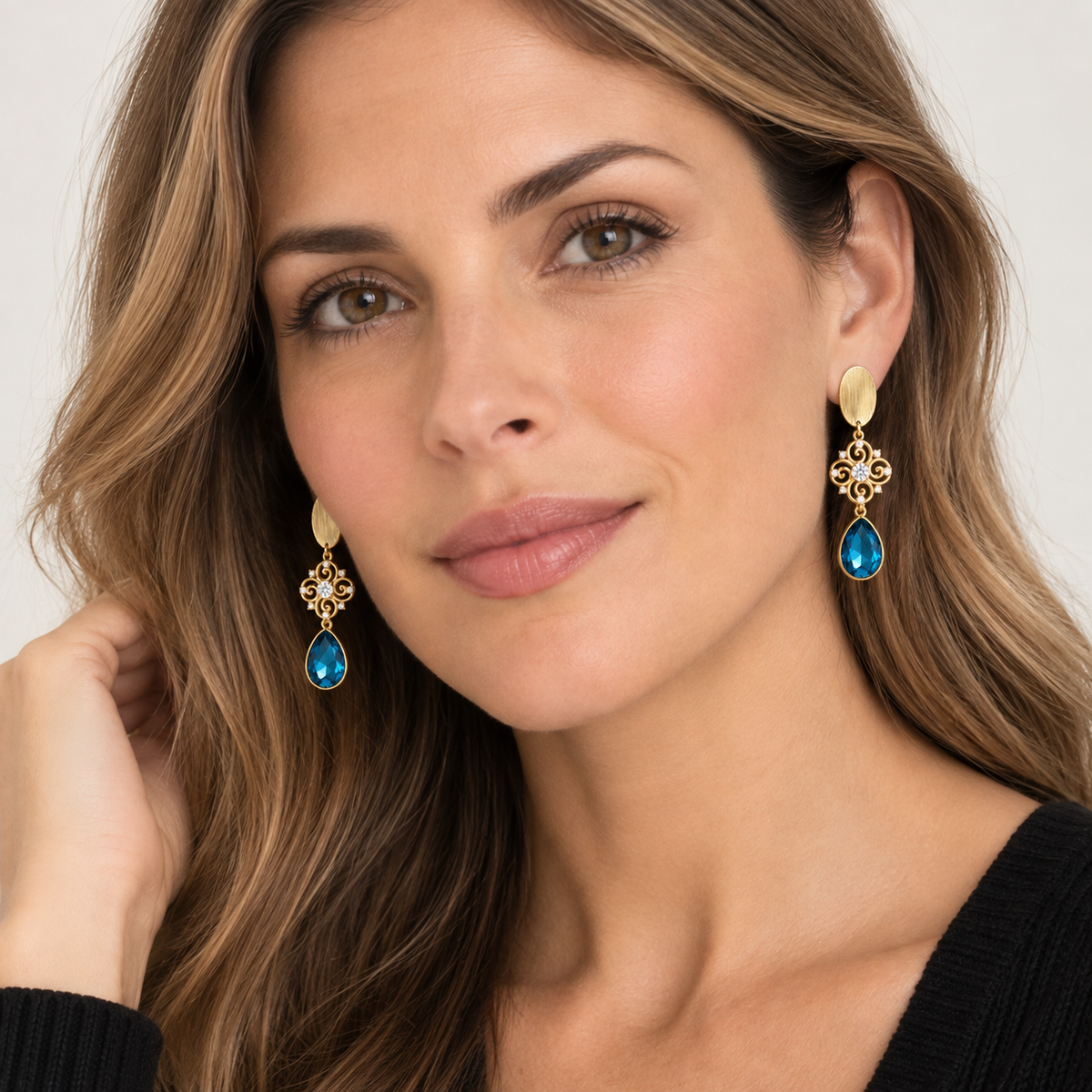 Modelo luciendo Aros Azul Imperial dorados con cristal azul facetado de MCJoyas