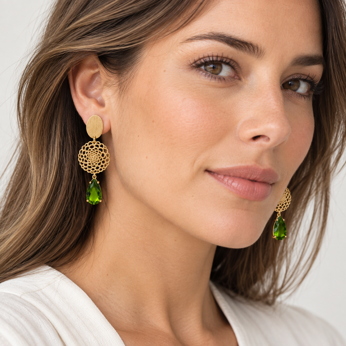 Modelo luciendo Aros Esmeralda dorados con cristal verde en forma de gota – MCJoyas.
