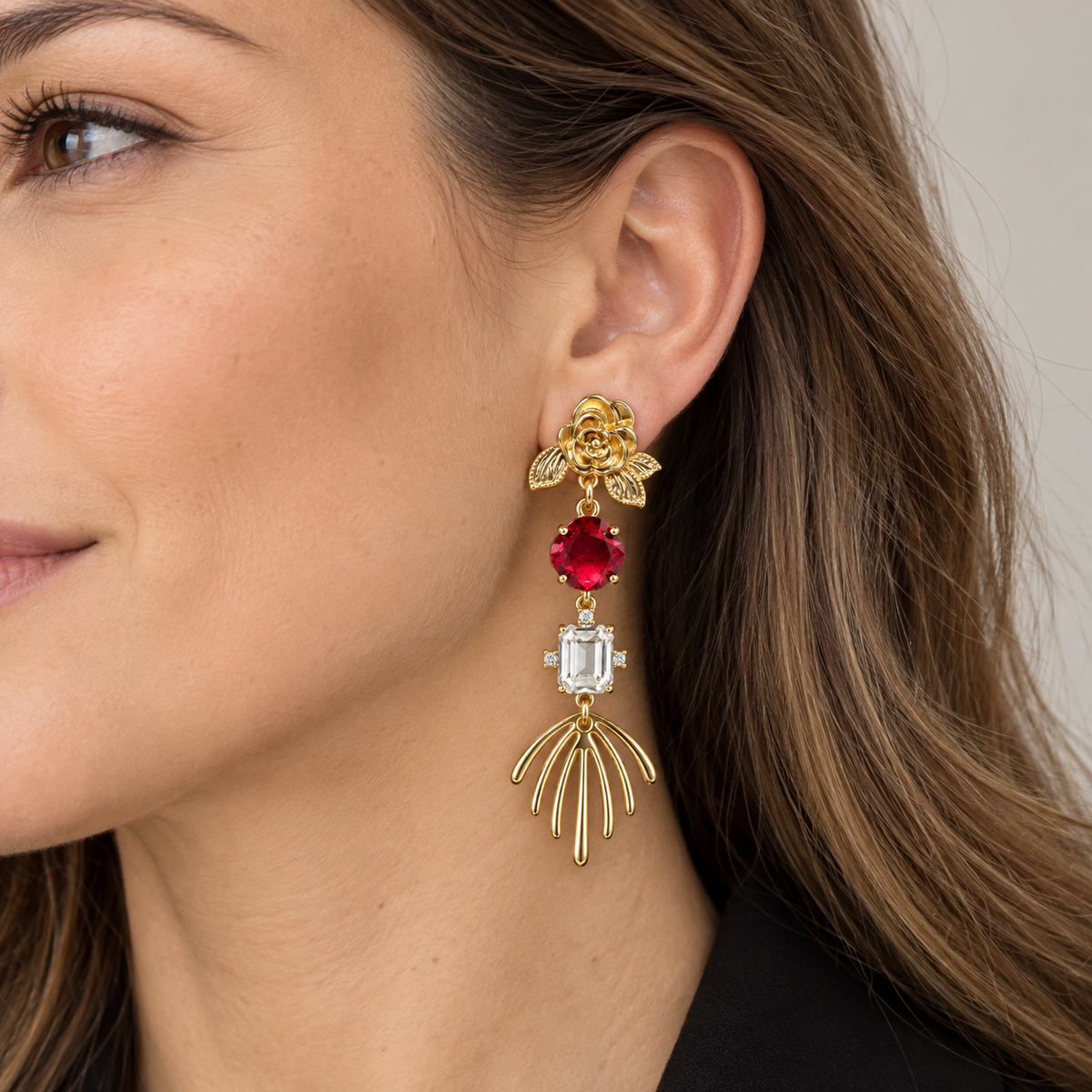 ros dorados largos con flor y cristales rojos puestos en modelo, diseño elegante y llamativo de MCJoyas.