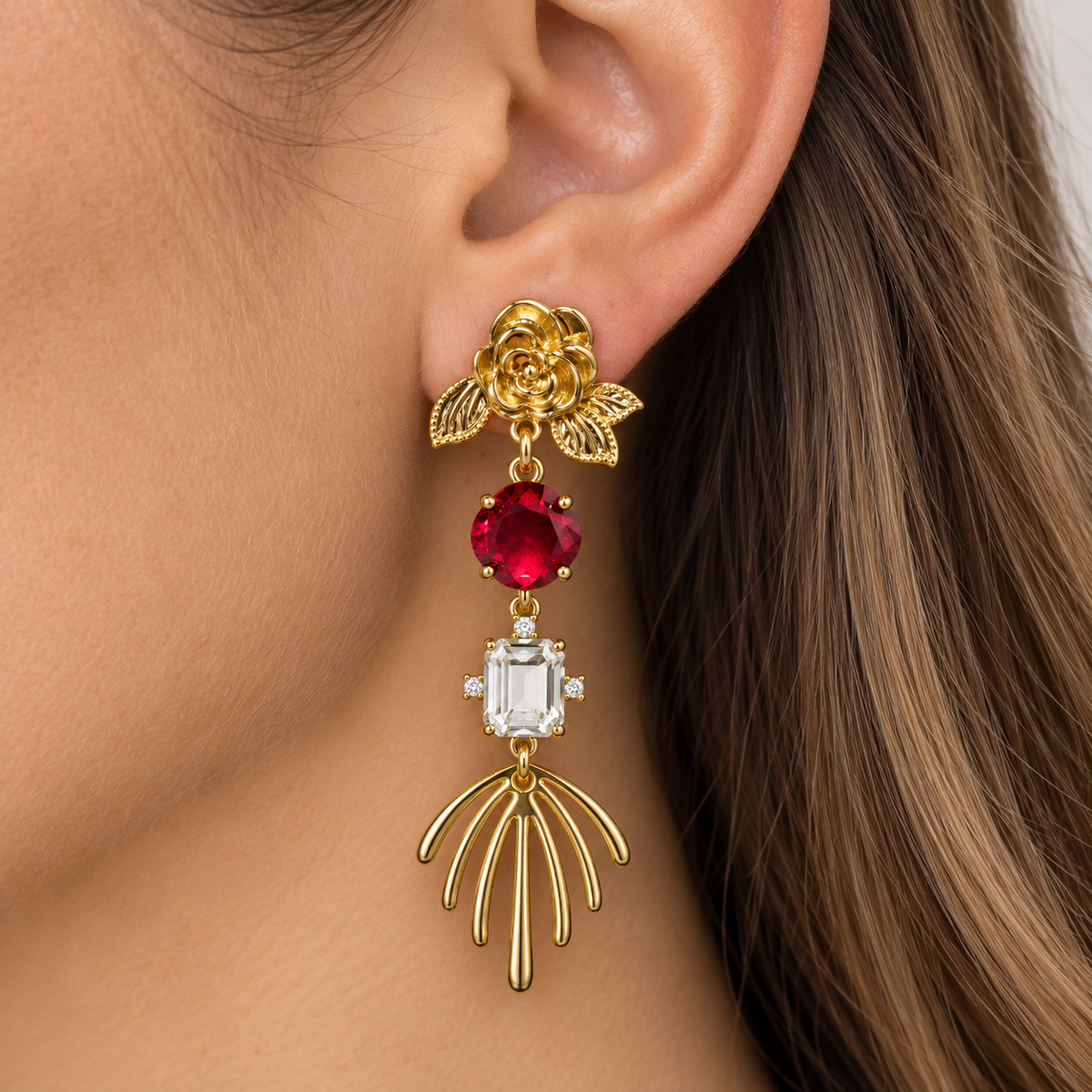 ros dorados largos con flor y cristales rojos puestos en modelo, diseño elegante y llamativo de MCJoyas